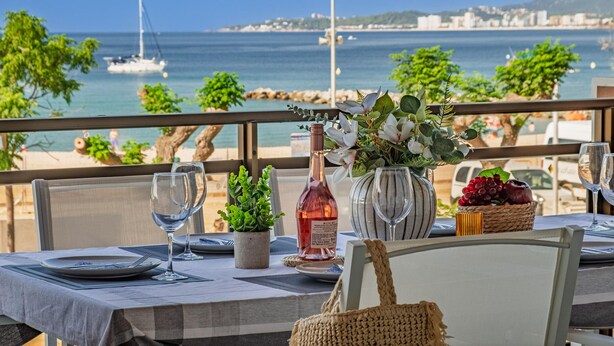 A table set for dining with a view of the sea and boats in the background. - Beautiful sea-view apartment with WiFi and parking in Palamós (Palamós)