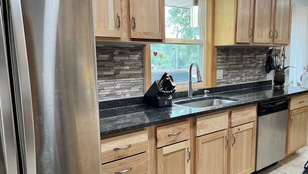 A modern kitchen with wooden cabinets, a stainless steel refrigerator, a granite countertop, and a dishwasher. - Charming, Private , 3BR, 1Bath Main Floor Close to all action Stadiums & Sports (Minneapolis)