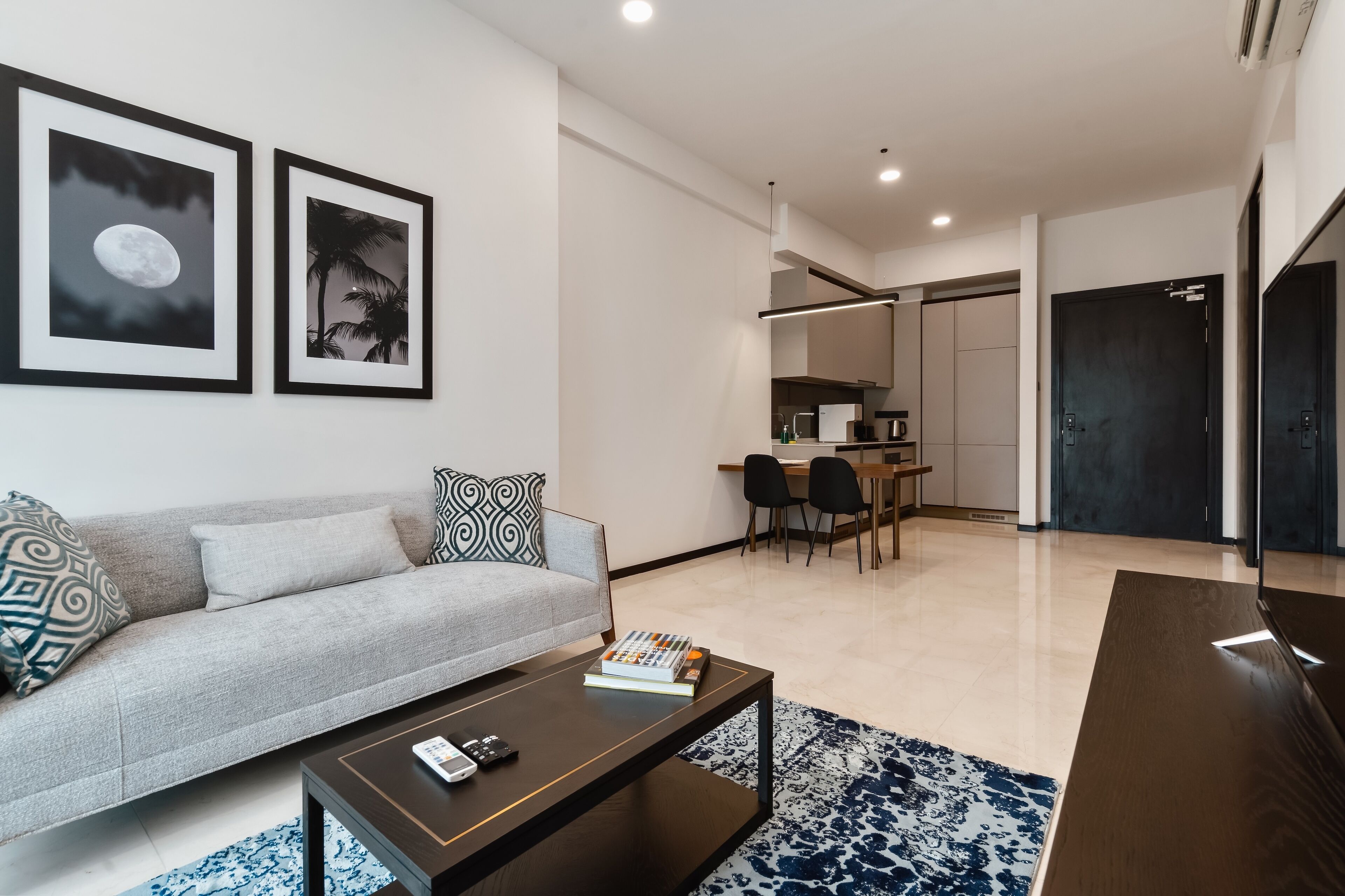 A modern living room with a sofa, coffee table, and framed pictures on the wall.