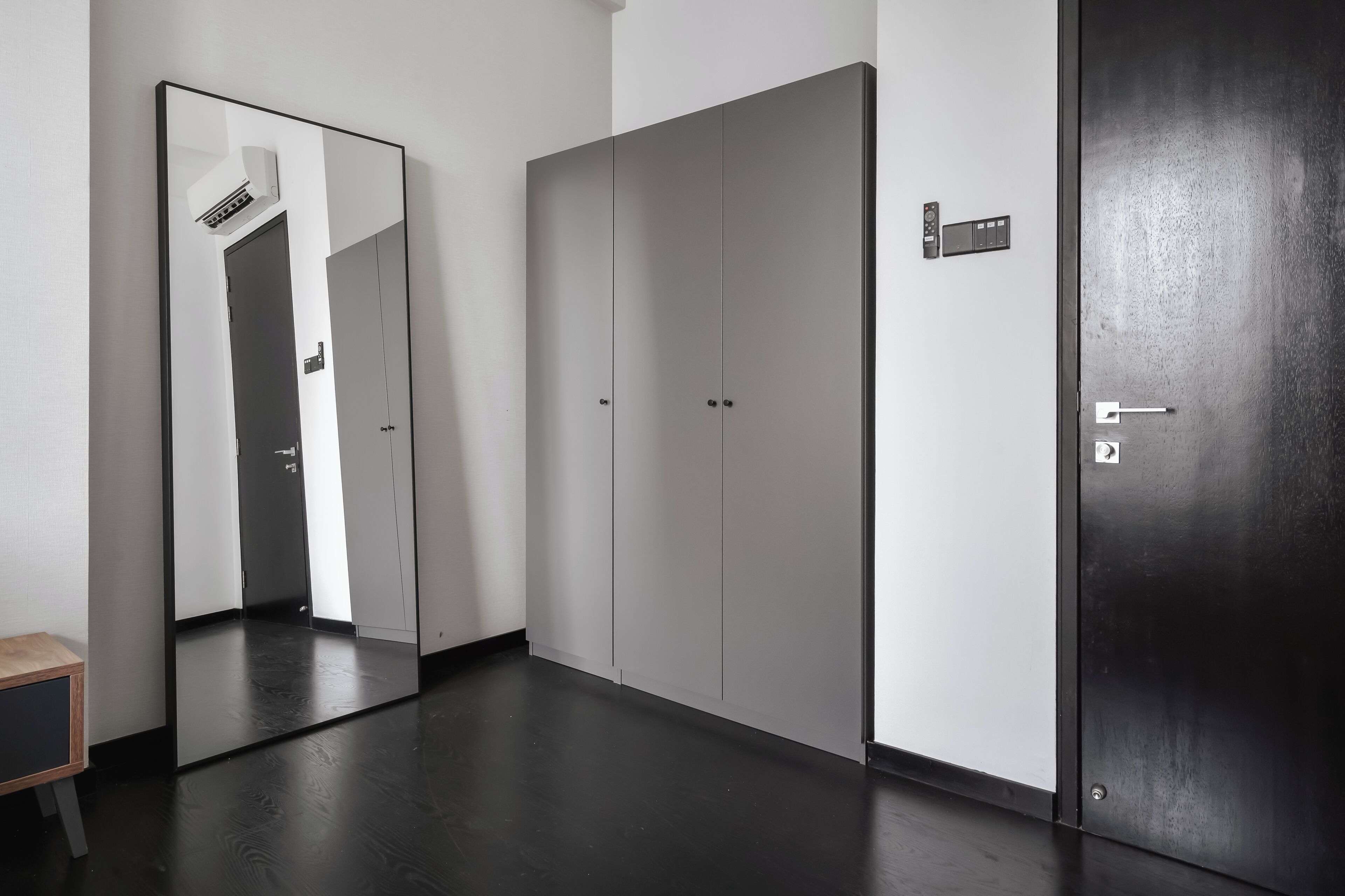 Una habitación con un espejo grande, un armario y una puerta con cerradura.