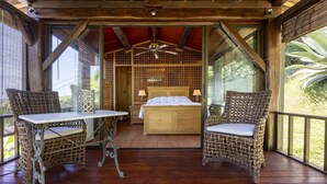 A wooden deck with a bed, two wicker chairs, a table, and a ceiling fan. - Villa Loupa - Calm and Harmony (La Colle-sur-Loup)