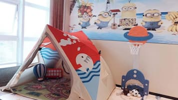 A room with a tent, a hot air balloon, a basketball hoop, and a mural of Minions on the wall.