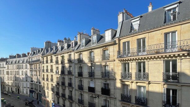 A row of classic European townhouses with multiple balconies and large windows. - Studio Quartier Latin & Seine (Paris)