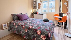 A compact bedroom with a bed, a small desk, and a chair. - Studio Quartier Latin & Seine (Paris)