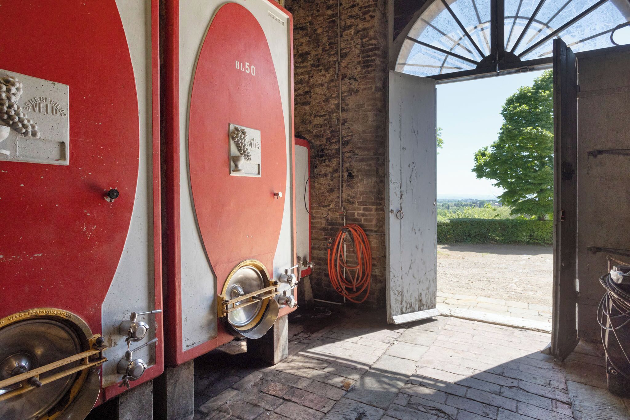A fire engine with a brass door handle and a hose coiled nearby.