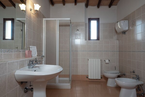 A bathroom with a shower, two sinks, a toilet, and a mirror. - Borgo Villa Certano (Siena)