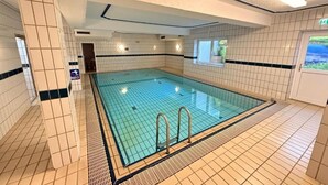 An indoor swimming pool with tiled walls and floor, a clear pool, and a window with a view. - Apartment in Zwiesel Bavarian Forest, sauna, pool, Wi-Fi (Zwiesel)