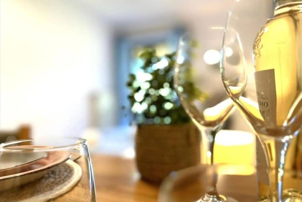 Une table avec une bouteille de vin blanc et un verre à vin.