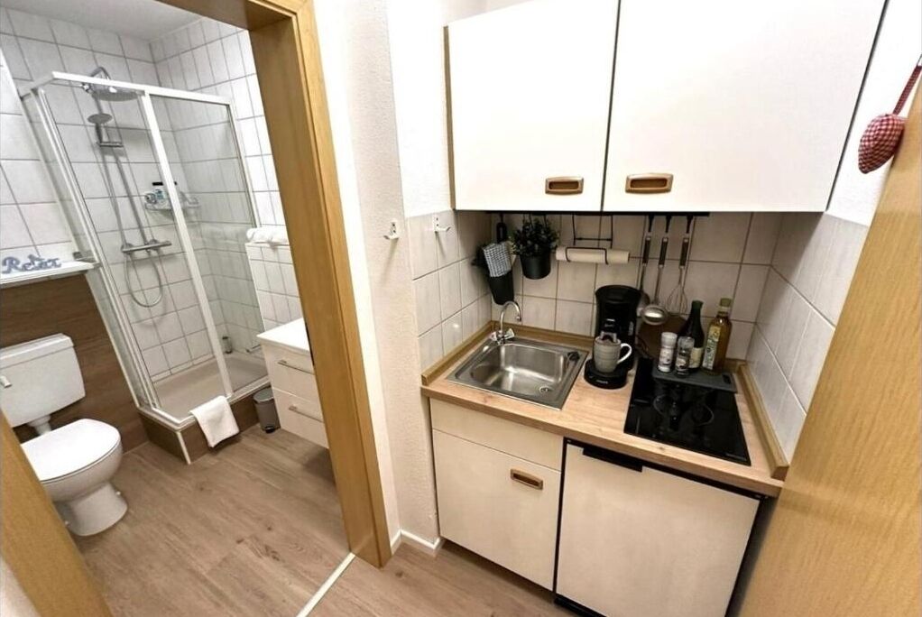 A compact bathroom with a shower, toilet, and sink.