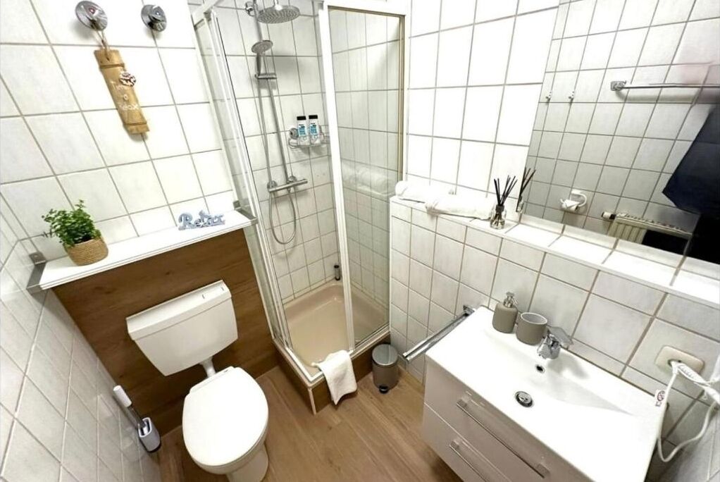 A modern bathroom with a toilet, sink, and shower area.