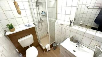 A modern bathroom with a toilet, sink, and shower area.