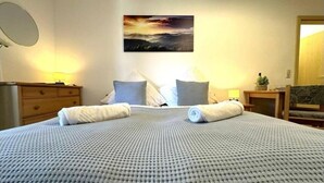 A neatly made bed with a textured blanket, two pillows, and rolled towels on a wall-mounted headboard. - Apartment in Zwiesel Bavarian Forest, sauna, pool, Wi-Fi (Zwiesel)