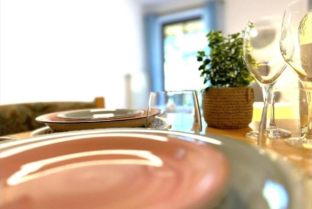 A dining table set with plates, glasses, and a woven basket.