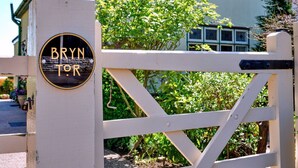 Una verja blanca con un letrero que dice 'BRYN TOR'.