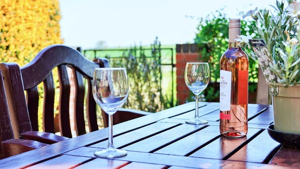 Una mesa con dos copas de vino y una botella.