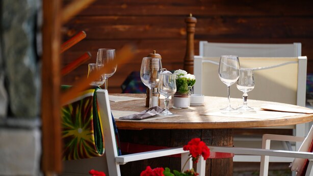 A wooden dining table with several wine glasses and a small potted plant. - Hotel Cime Bianche (Valtournenche)