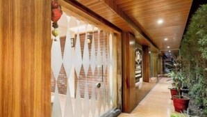 Un pasillo con paneles de madera y un vidrio con diseños geométricos.