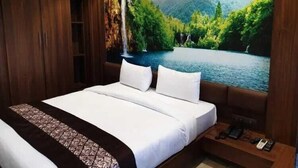 Un dormitorio con una cama grande, un armario de madera y un mural que muestra un bosque y un lago.