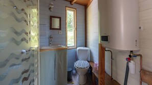 Een badkamer met toilet, wastafel en raam.