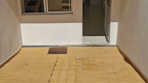 Une pièce avec un plancher en bois, une fenêtre avec des stores et un plafond blanc.