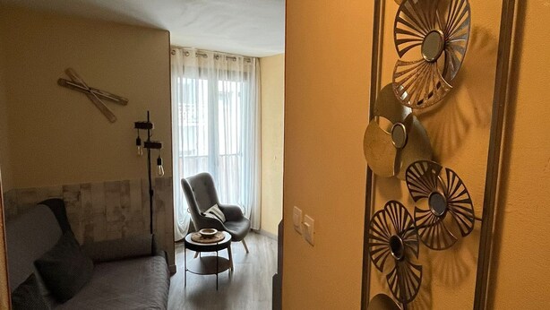 Una habitación de hotel con una cama, una silla y un adorno en la pared.