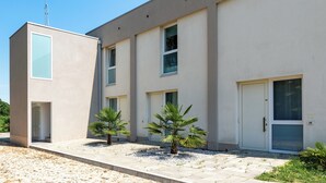 A modern building with a flat roof, large windows, and a door with a number. - Appia (Mestre)
