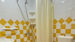 Une salle de bain avec une douche, des toilettes et un lavabo.