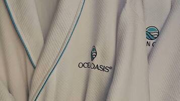 A white robe with blue piping and the OCEOASIS® logo.