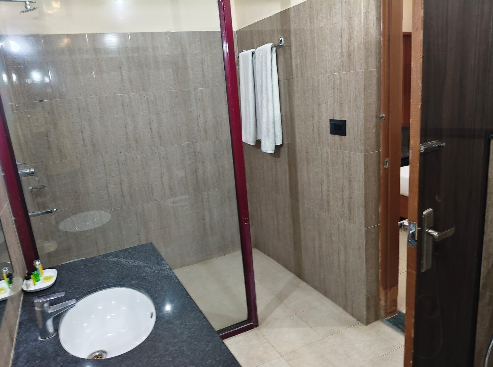 A bathroom with a sink, mirror, and shower area.