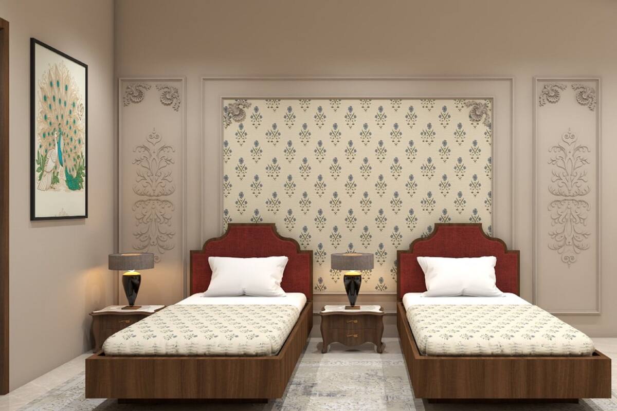 Ein Doppelzimmer mit gemustertem Wandpapier, zwei Nachttischen mit Lampen und einer großen Kübelpflanze.