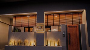A reception area with a G&B sign, wooden slatted windows, and a reception desk. - G B Urban Spa by Cretanhouses (Heraklion)