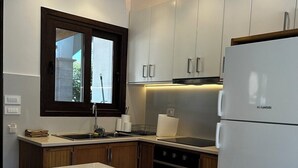 Une cuisine moderne avec des armoires blanches, un îlot central intégré et un réfrigérateur en acier inoxydable.