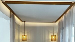 Une chambre à coucher moderne avec un grand lit, deux lampes de chevet et des rideaux légers.