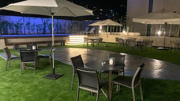 Una piscina al aire libre de temporada, sombrillas