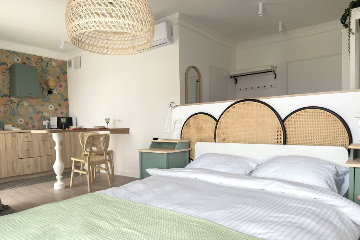 A bedroom with a bed, bedside tables, a desk, and a chair.