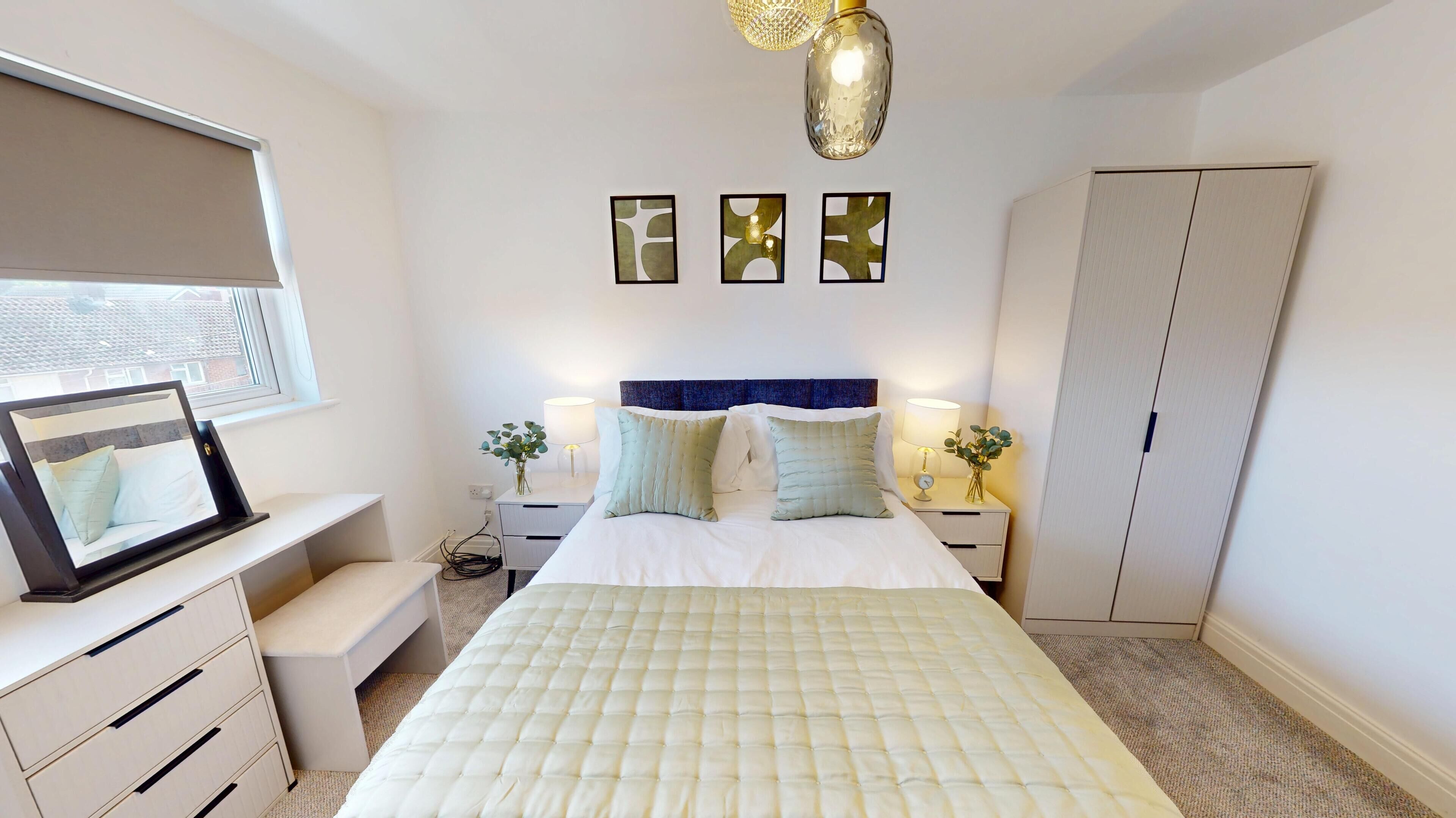 Un dormitorio con cama, mesitas de noche, armario, ventana con persianas y decoración en la pared.