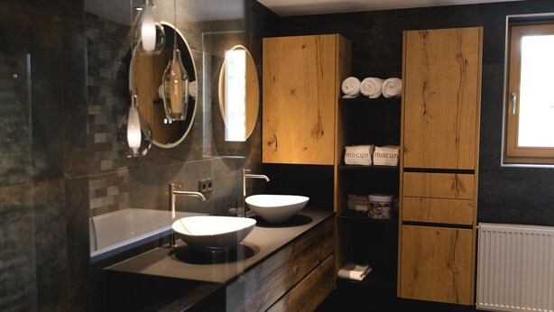 A modern bathroom with a large sink, two mirrors, wooden cabinets, and a window. - Penthouse at 1900 Meters Above sea Level (Soelden)