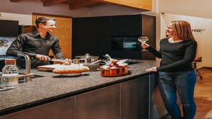 A modern kitchen with a central island, stainless steel appliances, and a wooden ceiling. - Penthouse at 1900 Meters Above sea Level (Soelden)