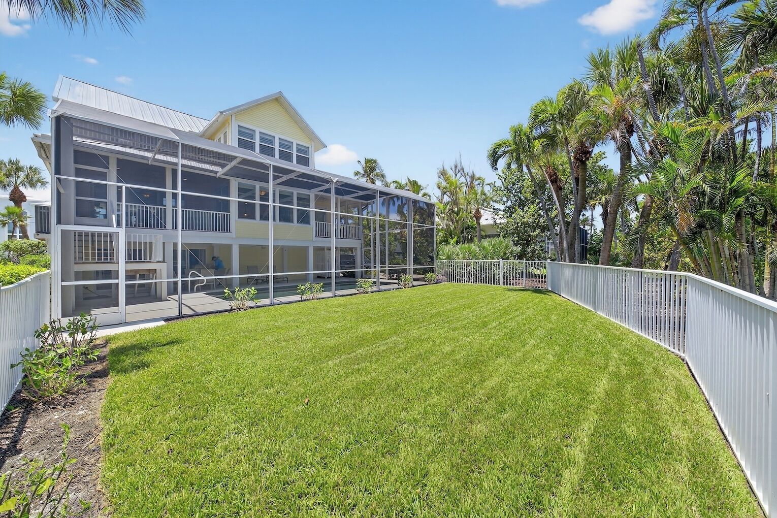 A modern two-story house with large glass windows and a well-maintained lawn.