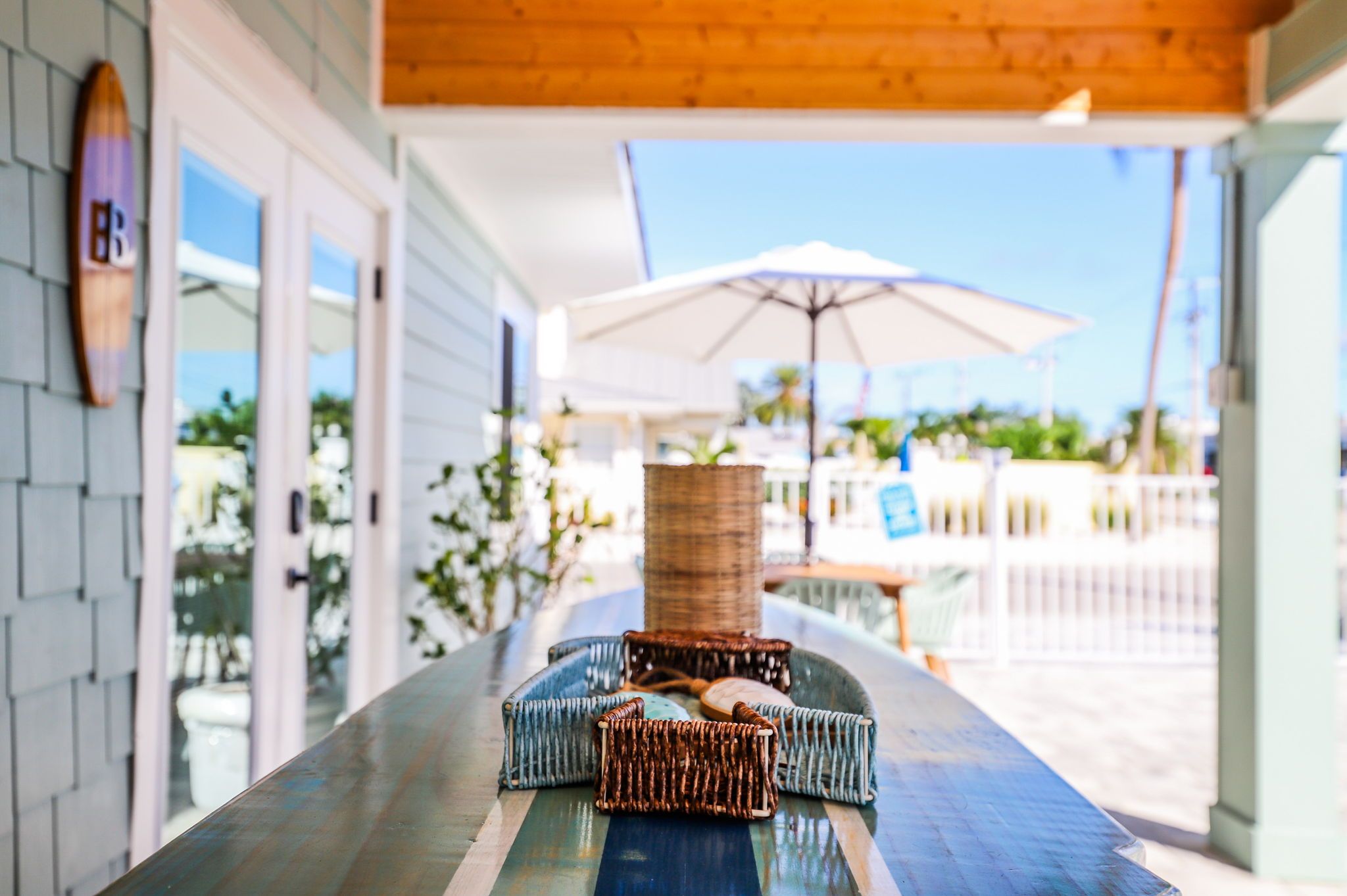 A covered outdoor seating area with wicker furniture and a table.