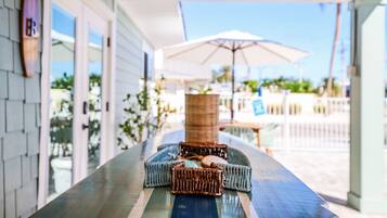 A covered outdoor seating area with wicker furniture and a table.
