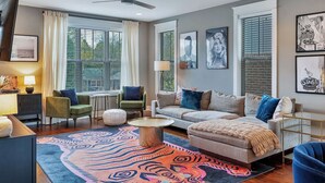 A modern living room with a sofa, chairs, a coffee table, and artwork on the walls.