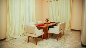 Un comedor con una mesa de madera, seis sillas y una alfombra.