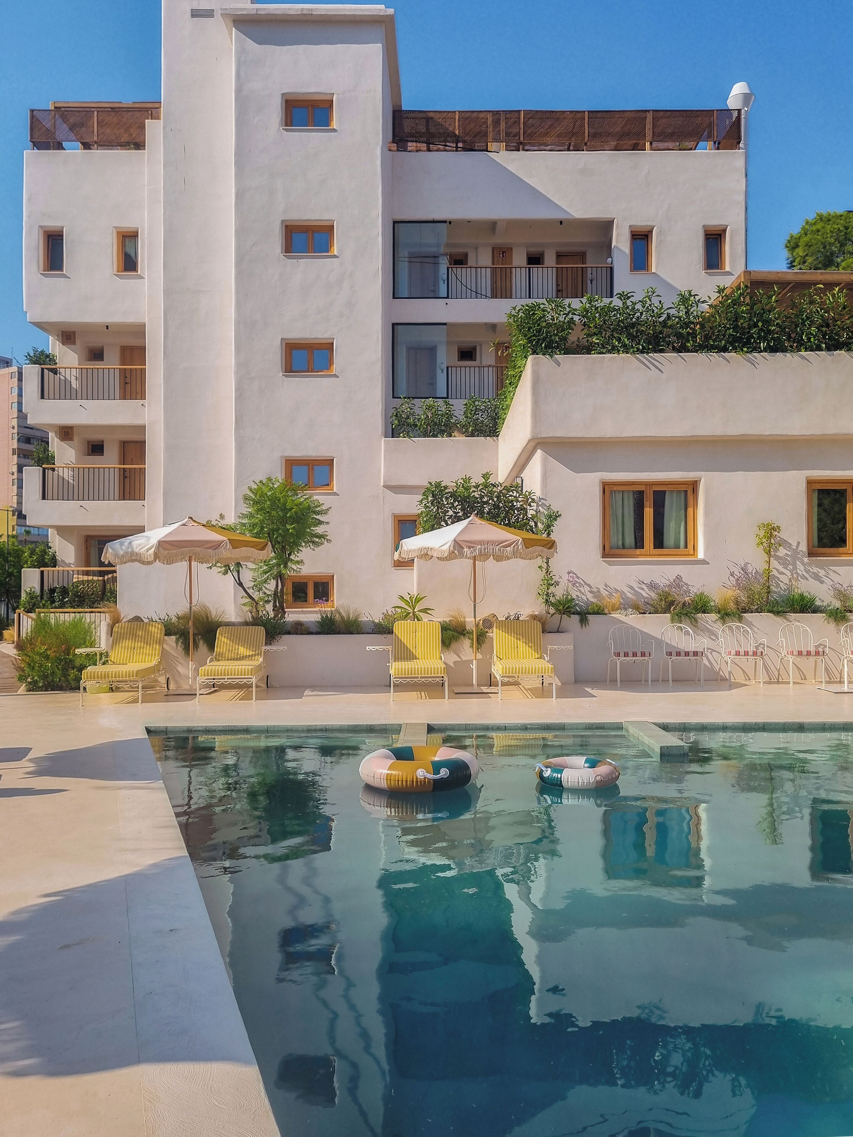 Una piscina cubierta, una piscina al aire libre, sombrillas, tumbonas