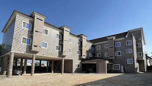 A multi-story building with a stone facade, multiple windows, and a covered entrance area. - Star of Africa Hotel (Abuja)