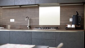 Een moderne keuken met een ingebouwde gasfornuis, een koffiezetapparaat en een magnetron.