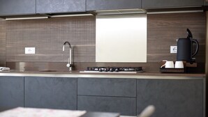 A modern kitchen with a built-in stove, a coffee maker, and a sink.