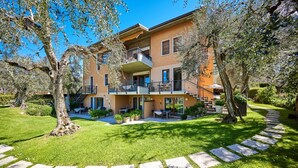 A multi-story building with a balcony, a staircase, and a well-maintained garden. - Residence Lilly-APT Jeneker- Garden with lake view, Residence Lilly - APT Jeneker - Giardino vista l (Malcesine)