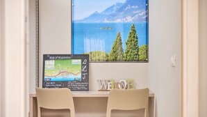 A room with a desk, two chairs, a map of Malcesin, and a 'WELCOME' sign. - Residence Lilly-APT Jeneker- Garden with lake view, Residence Lilly - APT Jeneker - Giardino vista l (Malcesine)