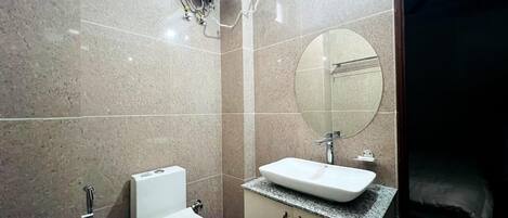 A bathroom with a toilet, sink, and mirror.